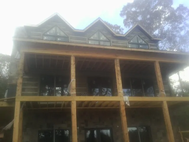 Dormers and porch framing on a large log home under construction — Roof Coating work by our crew in Pearisburg