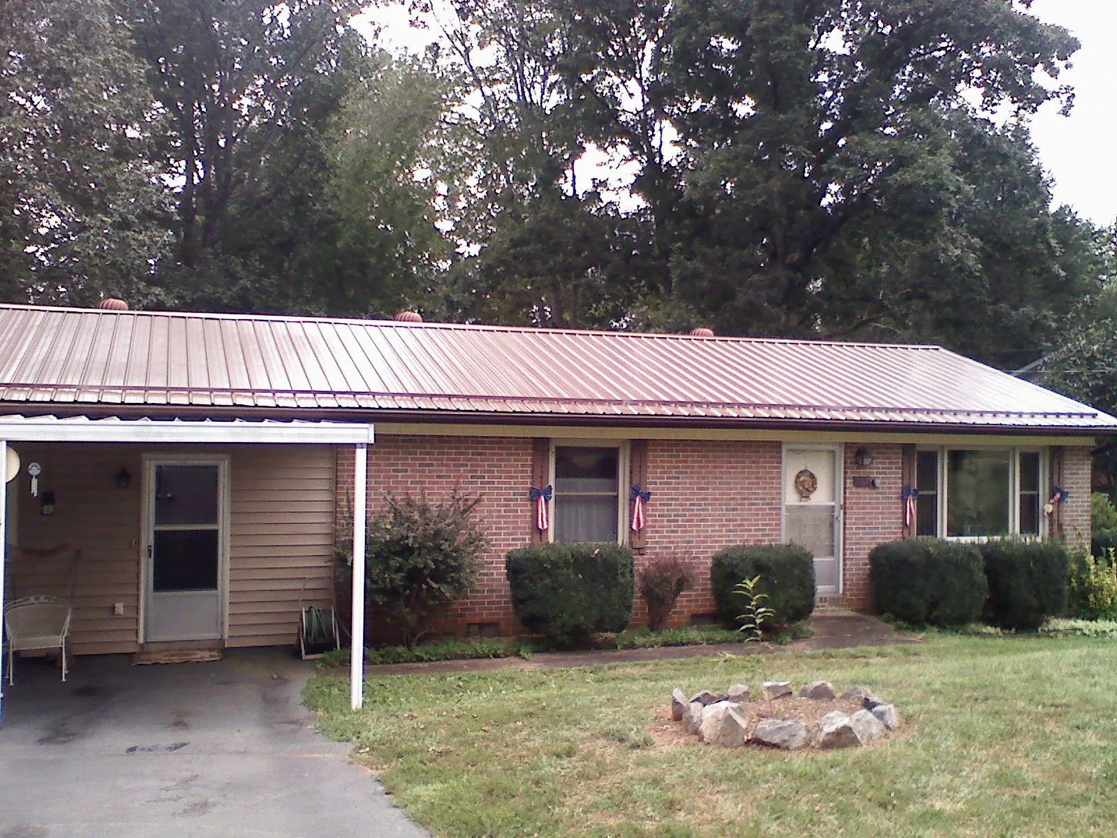 Bronze metal roof and carport on a brick ranch home — Roof Repair work by our crew in Pearisburg